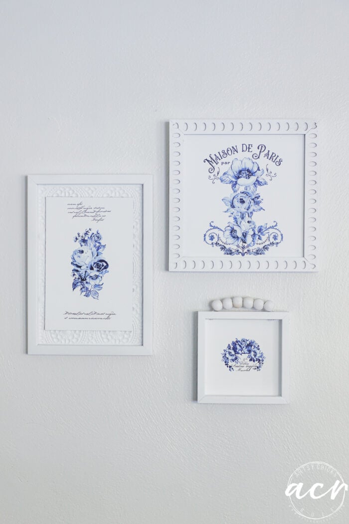 3 blue and white framed art arranged in grouping and hung on wall