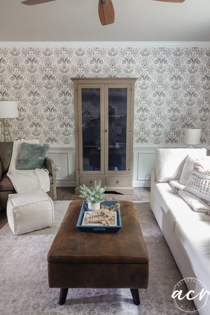 finished cabinet in room with ottoman and couch