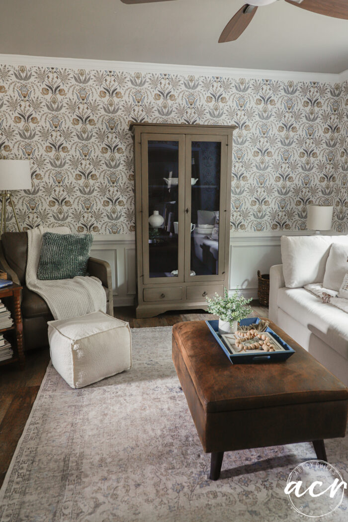 wood look cabinet in room with couch and chair