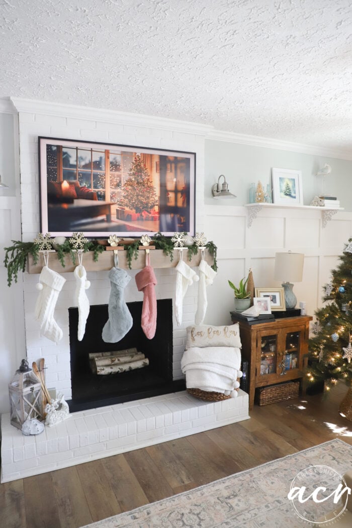 frame tv with image and fireplace with stockings