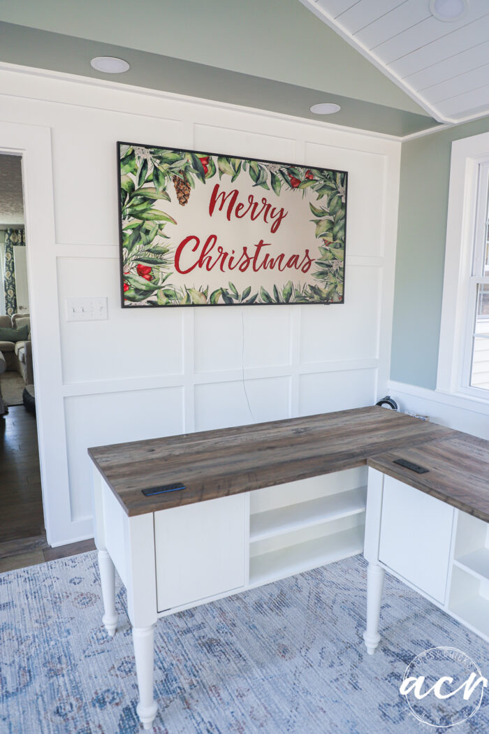 desks and large tv on wall with merry christmas image