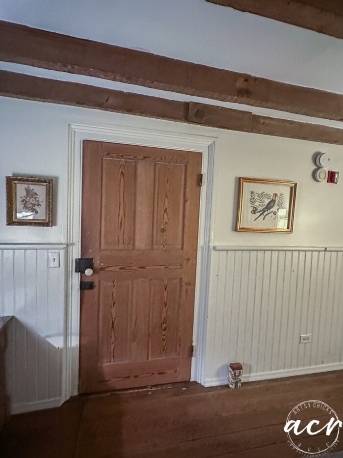 old wood door and old knobs and wood beamed ceiling
