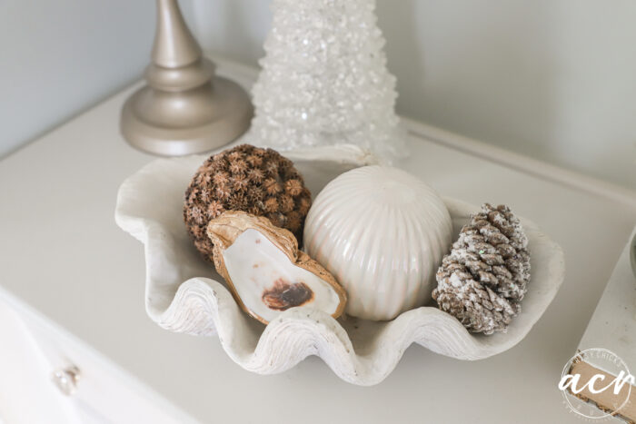dish with shells, decorative spheres and pine cone