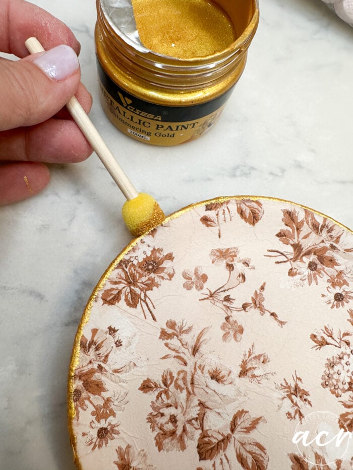 using the sponge applicator to apply the gold to the edge of decoupaged small plate
