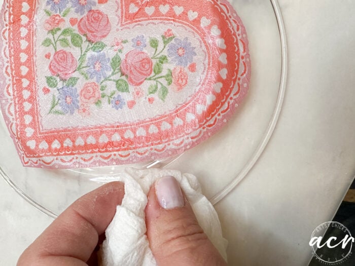 wiping away excess glue on back of plate