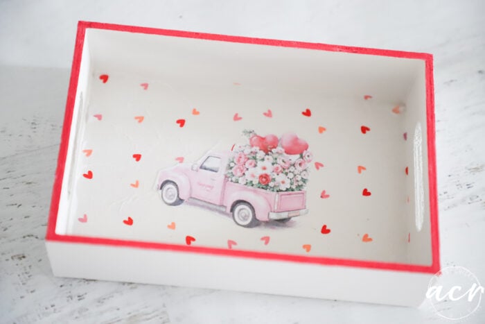 pink truck with hears on bottom of white tray outlined in red