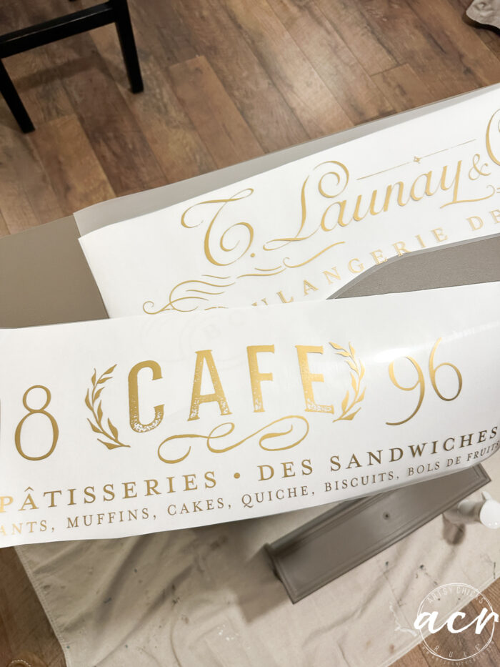 two gold script transfers on top of table