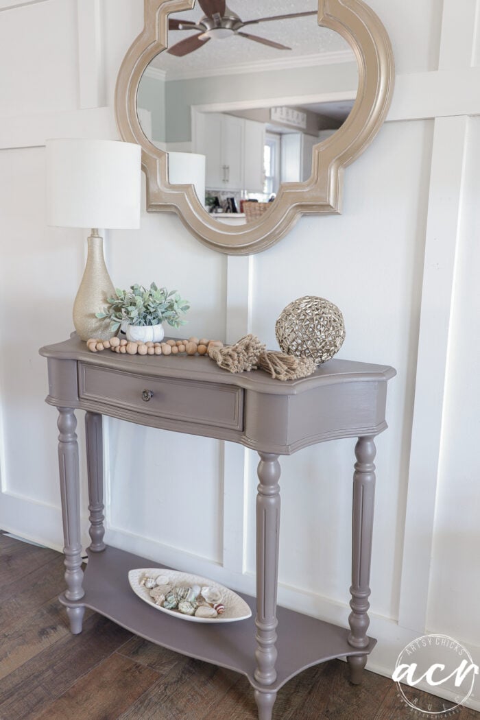 side view of table painted in wood wick decorated with various decor