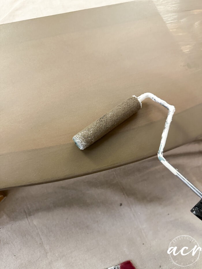 rolling the paint on the bottom shelf