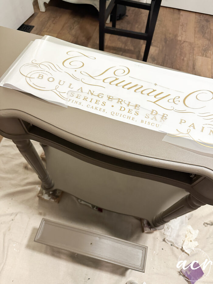 table painted and laying gold transfers script on top