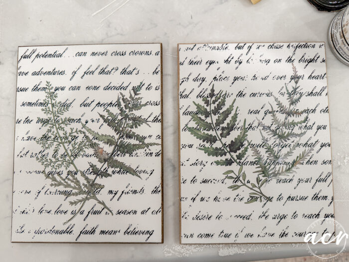 Two rectangular canvases from the Flipping Smalls Easter Edition feature handwritten script in black ink and botanical fern illustrations on a white background, displayed side by side on a marble surface.
