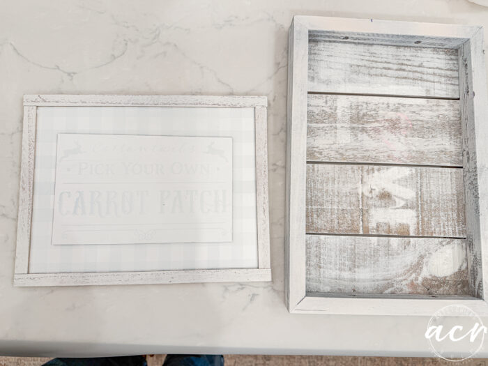 Two rustic, white-washed wooden frames on a marble surface. The left frame has faint Easter Edition text about a Carrot Patch. The right frame has a slatted wood interior and is empty. Flipping Smalls acy logo appears in the corner.