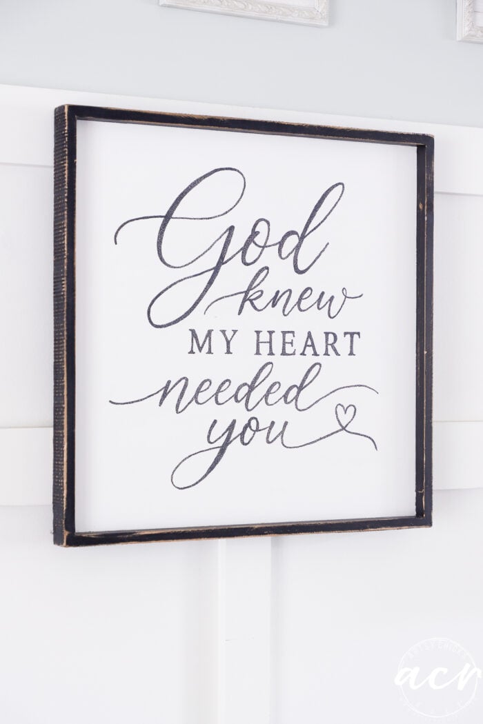 A thrifted redo, this framed God Knew My Heart Needed You sign features elegant script text with a small heart at the end. The dark wood frame adds warmth and charm, making it a meaningful piece of home decor that hangs beautifully on any white wall.
