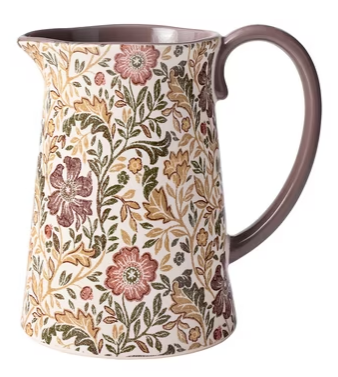 A ceramic pitcher with a curved handle, decorated with a detailed floral and leafy pattern in earthy tones of brown, green, gold, and soft red—this piece is a true celebration of fall favorites.