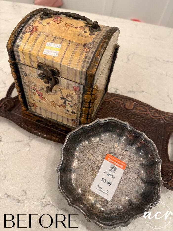 A vintage trinket chest and a tarnished silver bowl with Goodwill price stickers are displayed on a brown tray, ready for a Flipping Smalls transformation. The word BEFORE appears in the lower left corner.