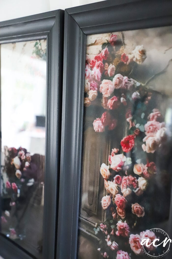 Two black-framed prints featuring a vintage-style painting of pink and red roses climbing over a wooden door, with soft, muted colors and a romantic, antique feel—perfect for adding timeless charm to your space. The delicate floral details are reminiscent of tissue paper petals, bringing an extra touch of elegance to these framed wall art pieces.