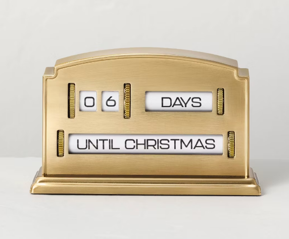 Gold-toned metal Christmas edition countdown clock displaying 06 DAYS UNTIL CHRISTMAS.