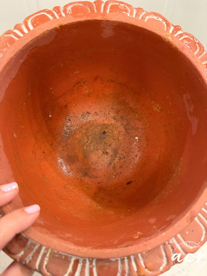 Top-down view of an empty, round, terracotta-style pot with a decorative scalloped rim, perfect for DIY concrete planters.